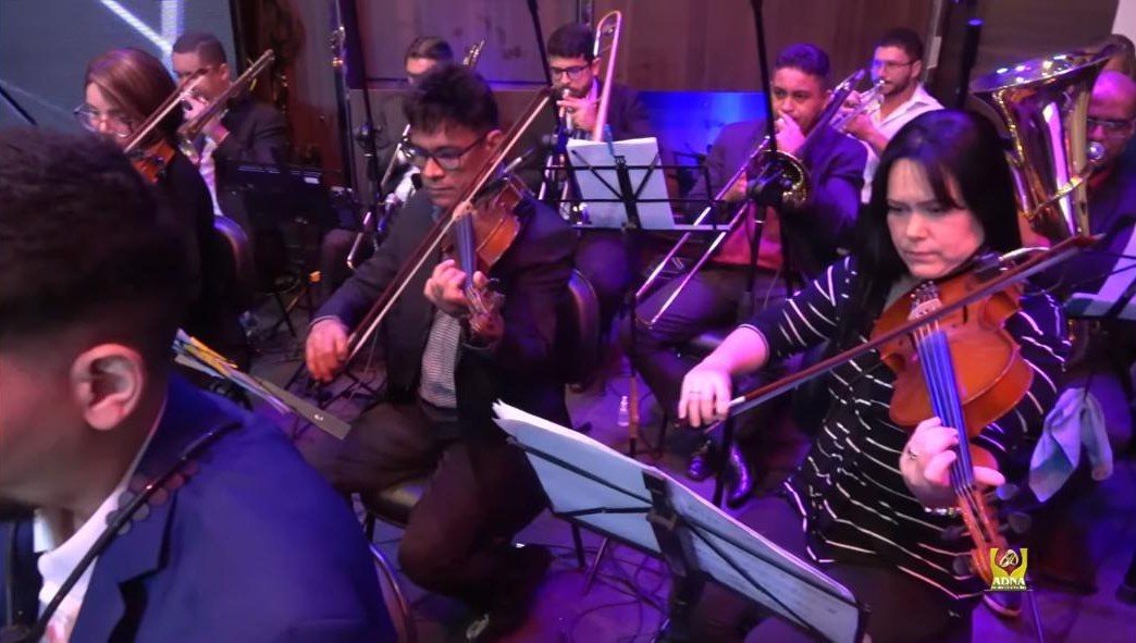 Violinos e metais da orquestra durante apresentação